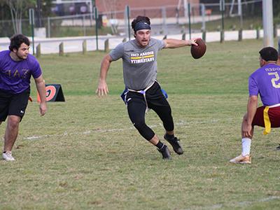 学生 playing flag football on campus.